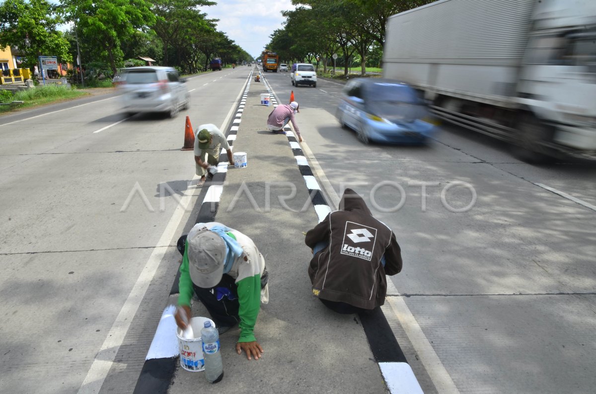 PENGECATAN PEMBATAS JALAN | ANTARA Foto