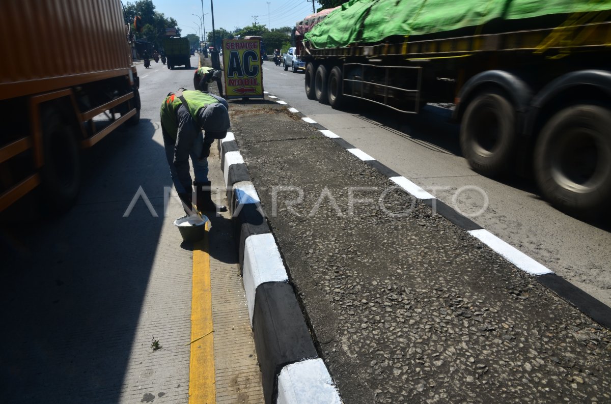 PENGECATAN PEMBATAS JALAN | ANTARA Foto