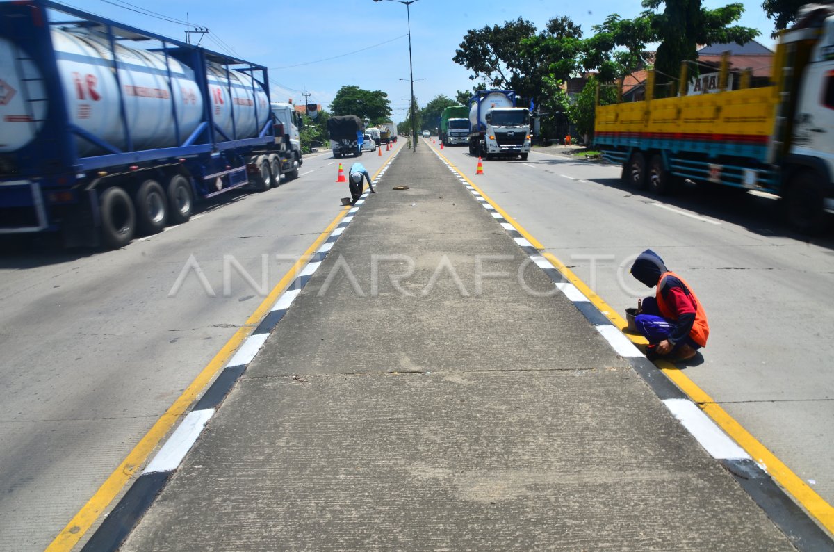 PENGECATAN PEMBATAS JALAN | ANTARA Foto