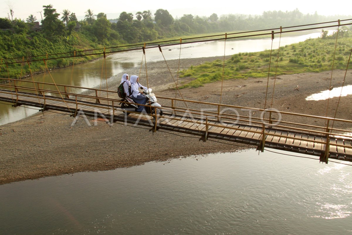 Guru melintasi jembatan gantung di pedalaman Jambi
