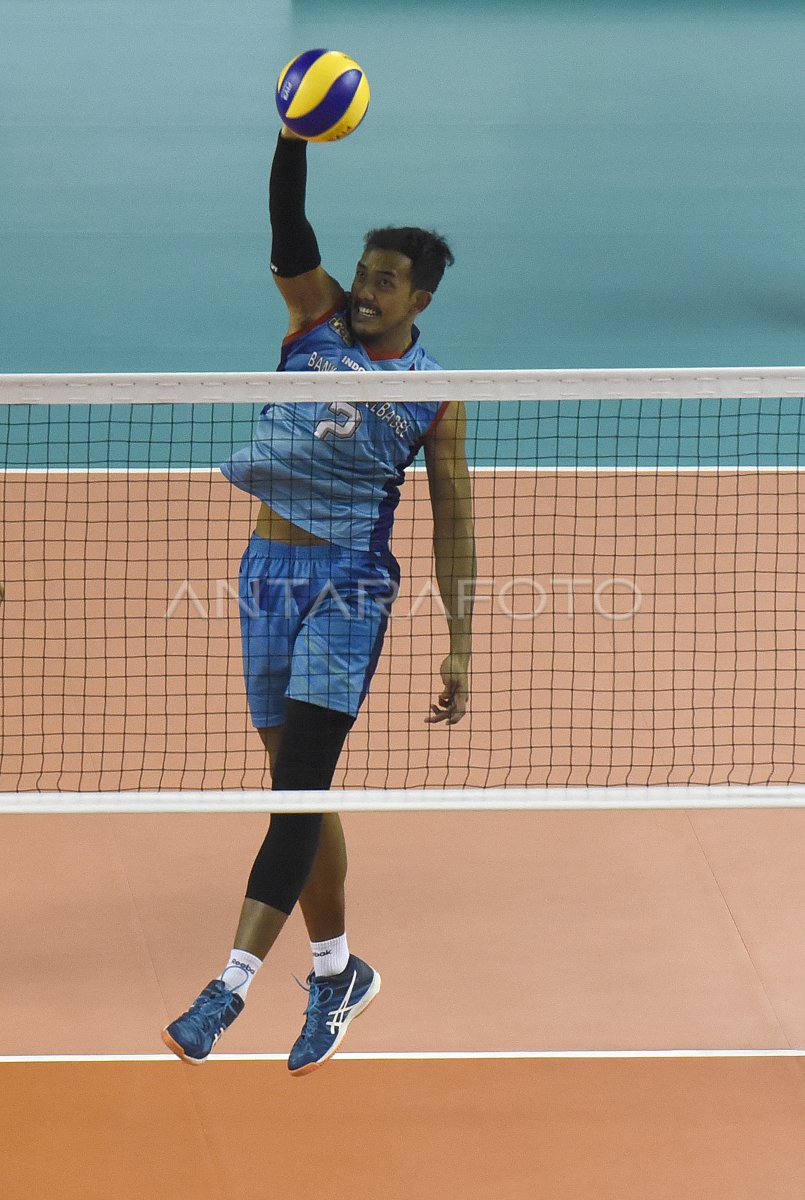 Pemain bola voli putra melakukan blok di depan net